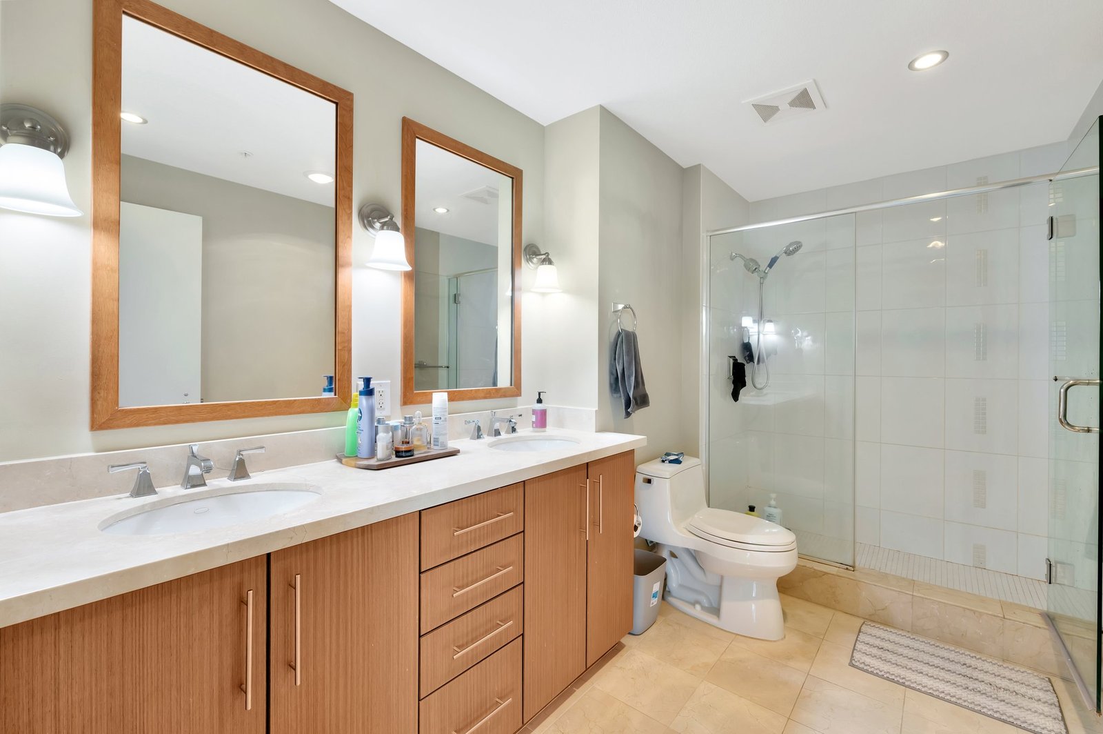 primary bath with dual-sink vanity and glass shower
